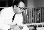 Batson with an infant, 1950s by Blair E. Batson and University of Mississippi. Medical Center