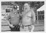Police offier posing with a tattooed gentleman at a blues festival by Scott M. Bock