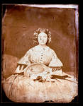 Unidentified woman, sitting on a sofa, holding a hat by Edward C. Boynton