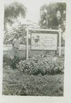 Unidentified man posed with the Tinian Tavern sign