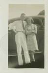 Unidentified couple posed in front of a car