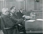 Claude F. Clayton seated seated at confirmation hearing with two unidentified men. by Author Unknown