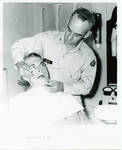 Military dentist working on man. by Author Unknown