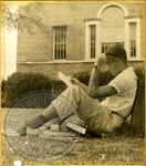 Young man studying under tree by J. R. Cofield