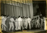Men in pajamas at nighttime pep rally by J. R. Cofield