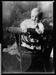 William Faulkner, one years old, standing in chair holding candy by Unknown