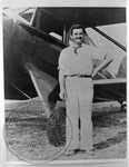 William Faulkner smiling, standing in front of his plane by Unknown