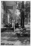 William Faulkner standing on porch at Rowan Oak, drink in hand by Dan Brennan
