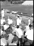 Scene of men in the bleachers at a football game by J. R. Cofield