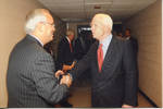John McCain shaking hands with unidentified man backstage at the Ford Center during the 2008 Presidential Debate at the University of Mississippi by Author Unknown