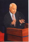 John McCain speaking behind a podium on stage at the Ford Center during the 2008 Presidential Debate at the University of Mississippi by Author Unknown