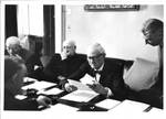 Unidentified men sitting at conference table. by Life