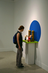 Attendee looks at Saved! By the Power of Corn by Adam Yungbluth and Photographer Unknown
