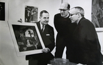 Examining a print by Photographer Unknown