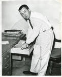 Unidentified man searching through desk by Author Unknown