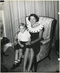 Young boy seated in woman's lap by Author Unknown