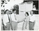 Carroll Gartin shaking hands with woman and two men by Author Unknown