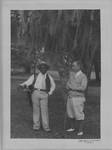 Unidentified man on golf course with African-American caddy. by Author Unknown