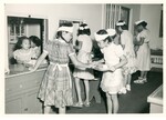 Students serving meals through window openings into a cafeteria. by Hawaii Donna Matsufuru Collection
