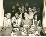 Children lining up to receive their lunch of 1/2 sandwich, apple, and two sides on metal plates. by Hawaii Donna Matsufuru Collection
