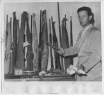 Albert Taylor, a border patrolman, displays weapons seized by Edward Movitz