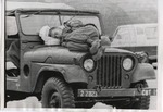 Soldier sleeps on the hood of his jeep by Edward Movitz