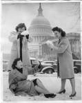 Three unidentified women playing in snow in front of U.S. Capitol. by Author Unknown