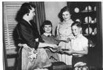 Mrs. Eastland serving the cake to Sue, Ann, and Woods Eastland in the dining room. by Author Unknown