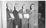 Eastland with three unidentified men holding American Farm Bureau Federation plaques for Distinguished and Meritorius Service. by Author Unknown