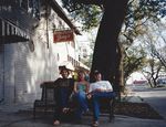 George, woman, Tate, on shady bench outside Tipitina's by Kudzu Kings (Musical group)