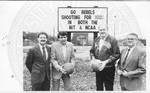 Ron Mote, Van Chancellor, Ed Murphy, and John Leslie in front of billboard. by Author Unknown