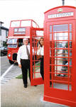 Mayor John Leslie and [woman] in front of double decker tour bus and phone box. by Author Unknown