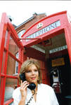 Woman posing in phone box, image 001 by Author Unknown