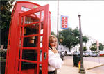 Woman posing in phone box, image 002 by Author Unknown