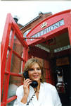 Woman posing in phone box, image 003 by Author Unknown