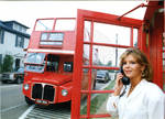 Woman posing in front of Oxford's double decker tour bus and phone box, image 001 by Author Unknown