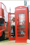 Woman posing in front of Oxford's double decker tour bus and phone box, image 004 by Author Unknown