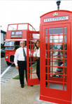John Leslie and woman in front of double decker tour bus and phone box, image 001 by Author Unknown