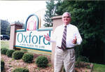 John Leslie in front of new Oxford welcome sign, image 002 by Author Unknown