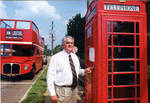 John Leslie in front of double decker tour bus and phone box on the Oxford Square. by Author Unknown