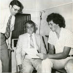 John Leslie wearing headphones with unidentified men. by Author Unknown