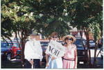 Three women holding signs by Author Unknown