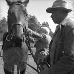 William Faulkner mounting horse, with Andrew Price holding the reigns, at Rowan Oak by Edwin E. Meek