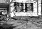Unidentified woman standing on front porch at Rowan Oak: Image 2 by Edwin E. Meek
