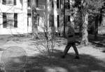 Unidentified man walking with camera on front lawn at Rowan Oak by Edwin E. Meek