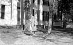 Unidentified woman walking on front lawn at Rowan Oak: Image 1 by Edwin E. Meek