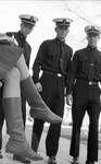 Three ROTC students staring at young woman's legs: Image 1 by Edwin E. Meek