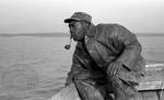 African American man with pipe on boat by Edwin E. Meek