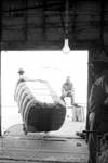 Men pulling bale of cotton by Edwin E. Meek