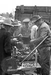Men looking at box of tools: Image 1 by Edwin E. Meek